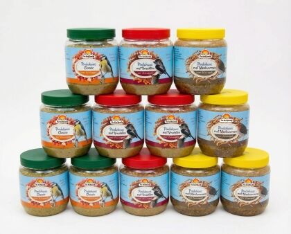 Vogelvoer vogelpindakaas potten gevarieerde smaken opgestapeld.